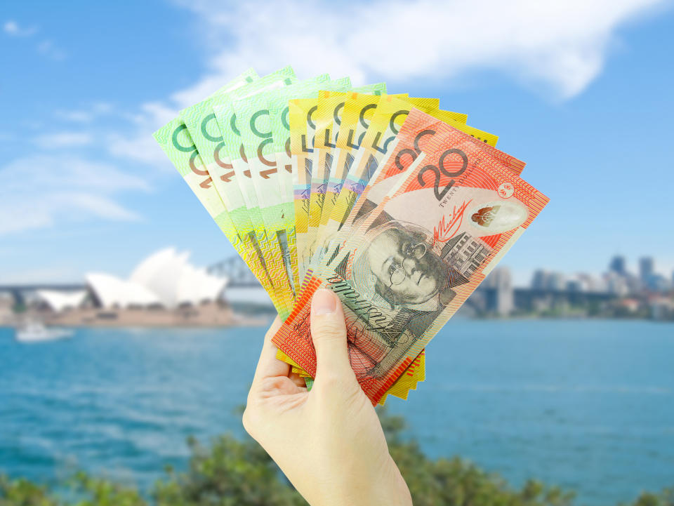 Pictured: Australian cash in hand at Sydney Harbour, suggesting wage growth in Australia. Image: Getty