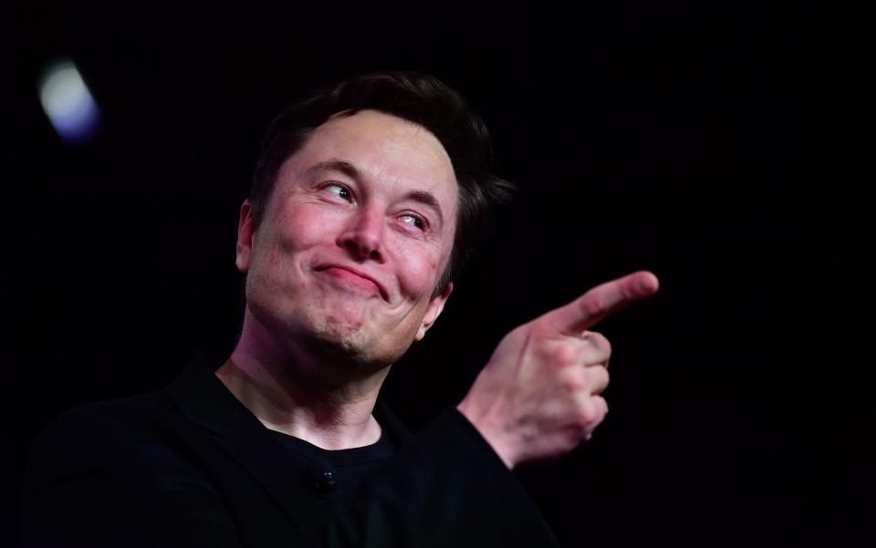 Tesla CEO Elon Musk points a finger while speaking during an interview.