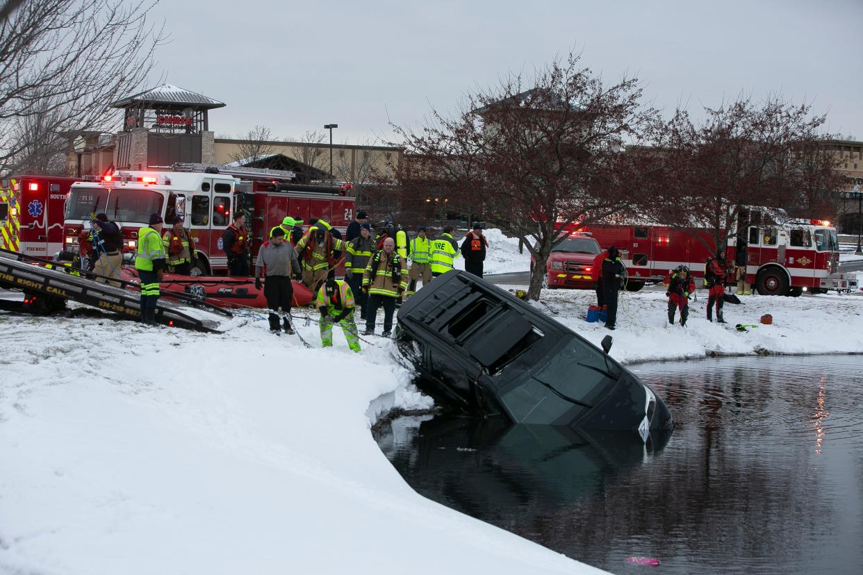 Rescue crews pull out a minivan that slid into a retention pond on University Drive in Mishawaka on Tuesday. Two children died in the incident.