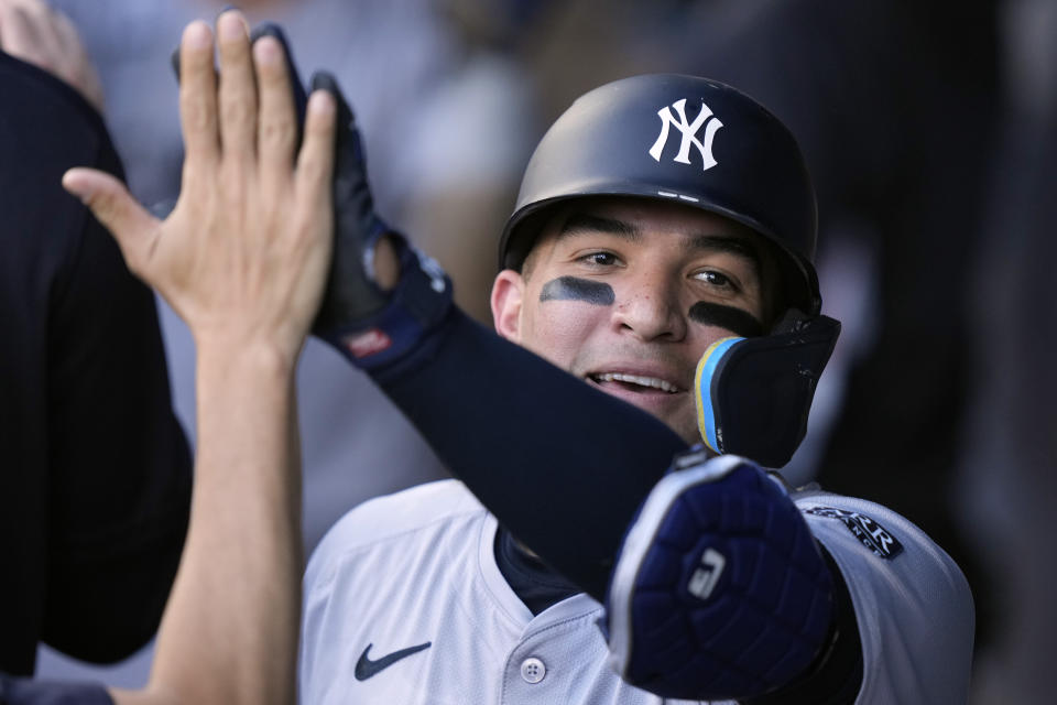 New York Yankees' Jose Trevino celebrates in the dugout after hitting a two-run home run during the first inning of a baseball game against the Kansas City Royals Wednesday, June 12, 2024, in Kansas City, Mo. (AP Photo/Charlie Riedel)