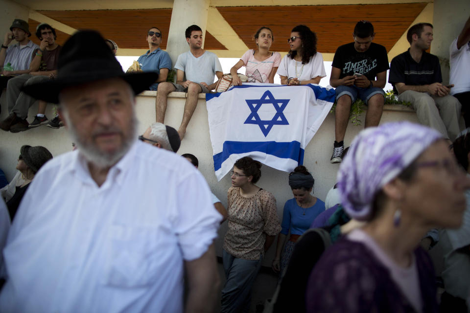 FILE - In this July 1, 2014 file photo, Israelis attend the funeral of three Israeli teenagers, Eyal Yifrah, 19, Gilad Shaar, 16, and Naftali Fraenkel, a 16-year-old with dual Israeli-American citizenship, in the Israeli town of Modiin. HBO's new docudrama series about the killings of four Israeli and Palestinian teenagers, which set off a cascade of events leading to the 2014 Gaza war, is set to air next week and is likely to reopen wounds on both sides of the conflict. “Our Boys,” co-created by Palestinian and Israeli filmmakers, presents a dramatized rendition of the chaotic events of that June following the abduction of three Israeli teens in the West Bank. (AP Photo/Oded Balilty, File)