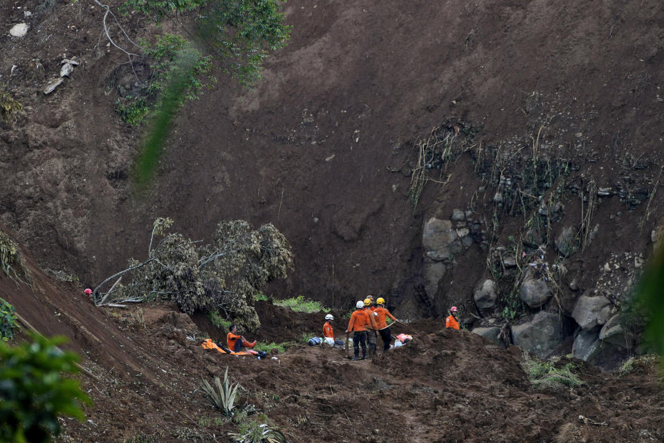 Rescuers search for victims at the site where an earthquake-triggered landslide hit in Cianjur, West Java, Indonesia, Friday, Nov. 25, 2022. The quake on Monday killed hundreds of people, many of them children and injured thousands. (AP Photo/Achmad Ibrahim)