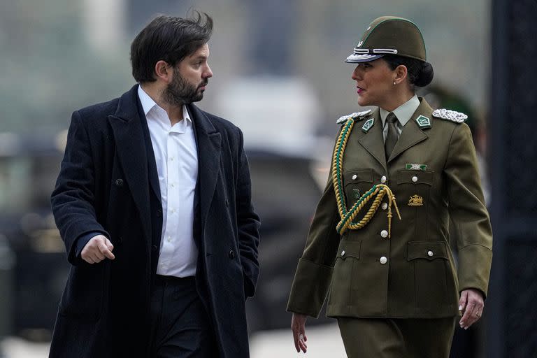 El presidente de Chile, Gabriel Boric, habla con el oficial militar a cargo de la seguridad presidencial a su llegada al palacio presidencial de La Moneda en Santiago de Chile, el lunes 30 de mayo de 2022. (AP Foto/Esteban Felix)