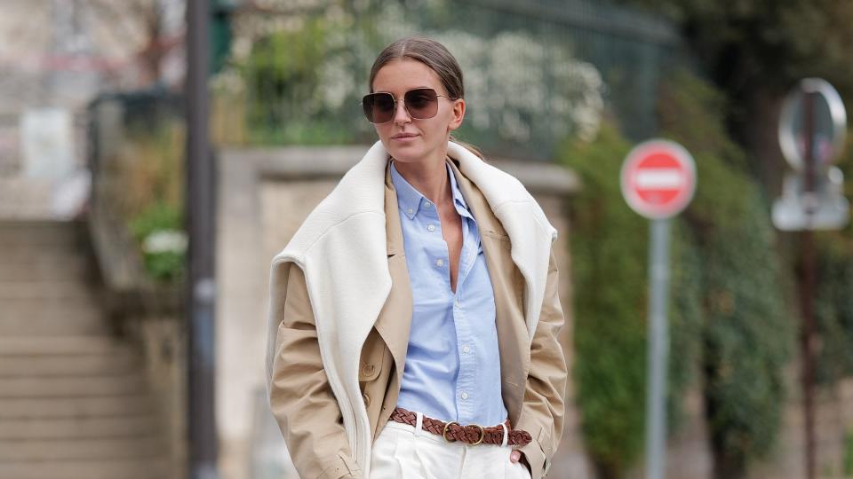 Woman wearing a trench coat with white trousers 