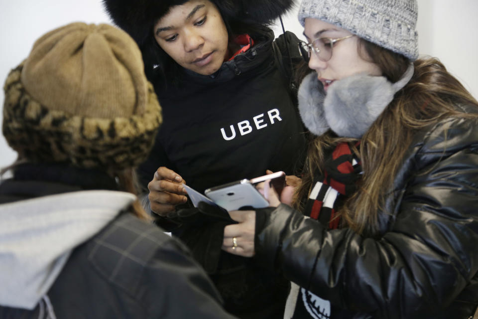 In this Wednesday, March 15, 2017, photo, an Uber representative helps travelers find rides with Uber at LaGuardia Airport in New York. Uber’s first report on employee diversity shows low numbers for women, especially in technology positions. Uber’s report doesn’t count drivers as employees. (AP Photo/Seth Wenig, File)