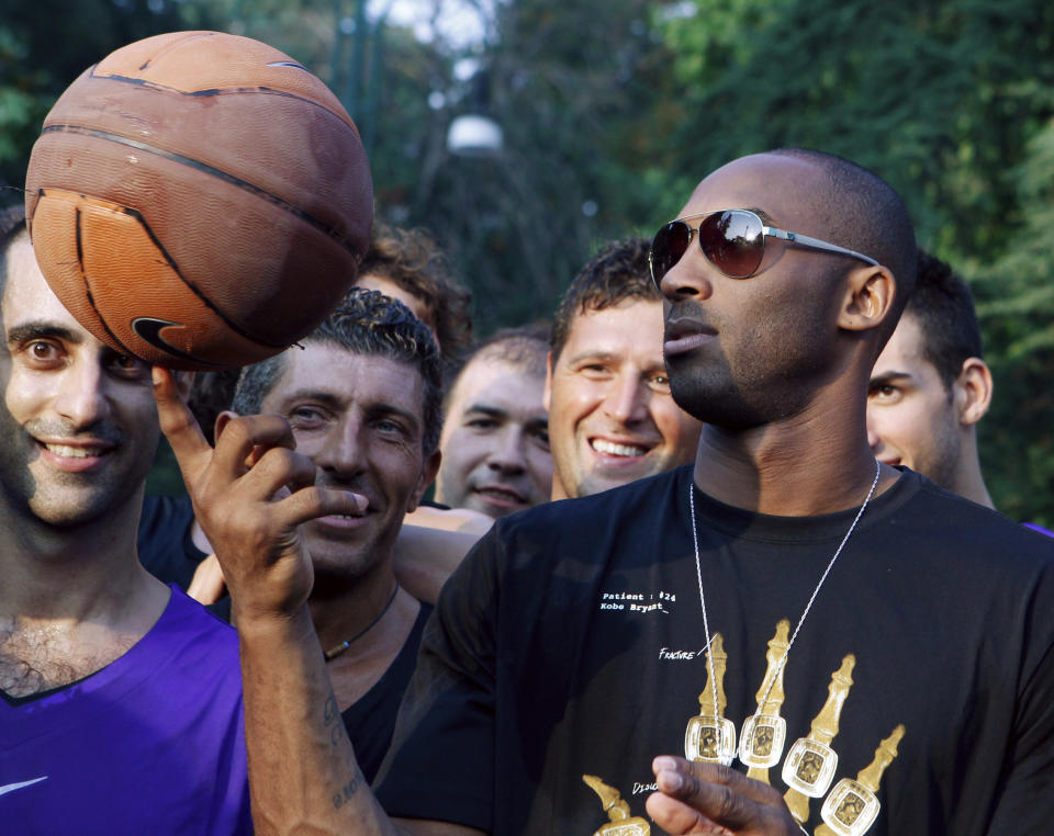 ARCHIVO - En esta foto del 28 de septiembre de 2011, el astro del básquetbol Kobe Bryant hace trucos con un balón durante un acto promocional en Milán, Italia. (AP Foto/Luca Bruno, archivo)