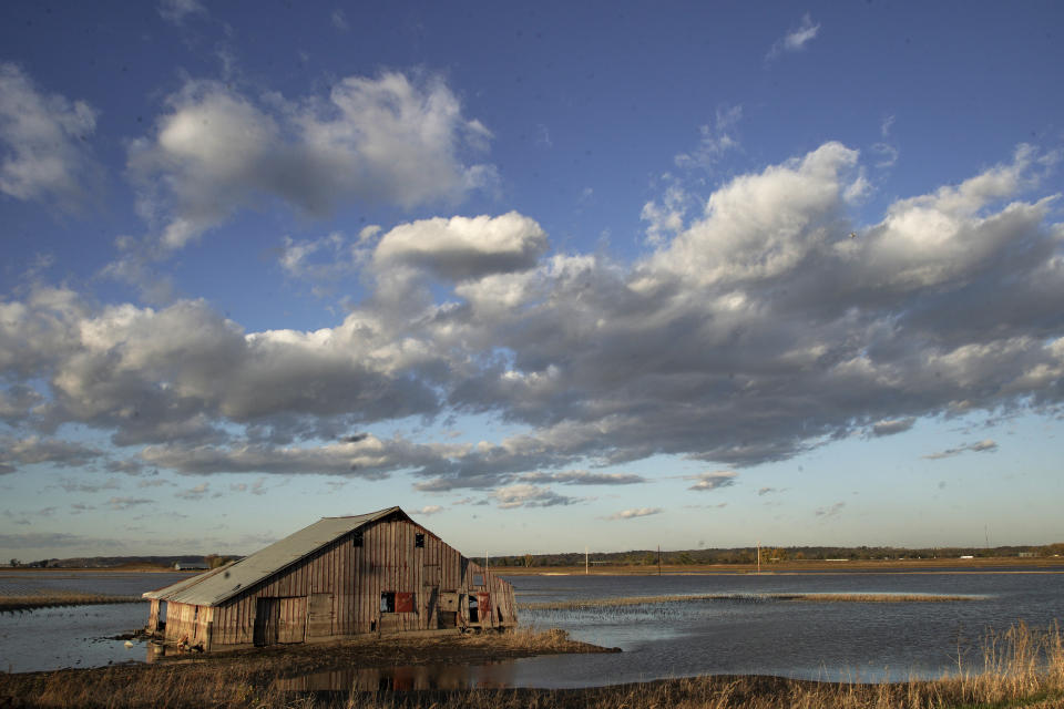 FILE- In this Oct. 22, 2019 photo, a barn sits in floodwaters in Pacific Junction, Iowa. The floodplain awaiting this year's surge is part of a changing picture, altered from just a few decades ago. It is now dotted with more parks, marshes and forests on land surrendered in recent years by communities and individuals. (AP Photo/Nati Harnik, File)