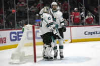 San Jose Sharks defenseman Jaycob Megna, right, congratulates San Jose Sharks goaltender James Reimer (47) after an NHL hockey game against the Washington Capitals, Wednesday, Jan. 26, 2022, in Washington. The Sharks defeated the Capitals 4-1. (AP Photo/Evan Vucci)