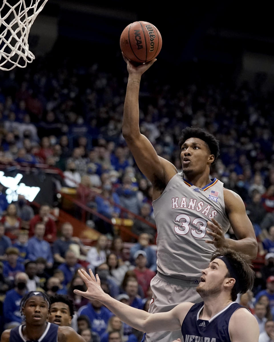 Kansas' David McCormack (33) shoots over Nevada's Will Baker during the first half of an NCAA college basketball game Wednesday, Dec. 29, 2021, in Lawrence, Kan. (AP Photo/Charlie Riedel)