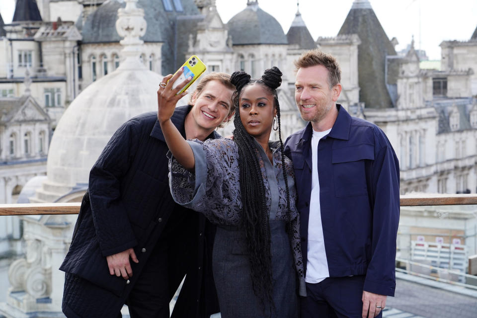 La actriz Moses Ingram, en el centro, toma una selfie con los actores Ewan McGregor, a la derecha, y Hayden Christensen durante una sesión de fotos por el estreno de la serie de Disney+ "Obi-Wan Kenobi", en el Hotel Corinthia en Londres, el jueves 12 de mayo de 2022. (Ian West/PA vía AP)