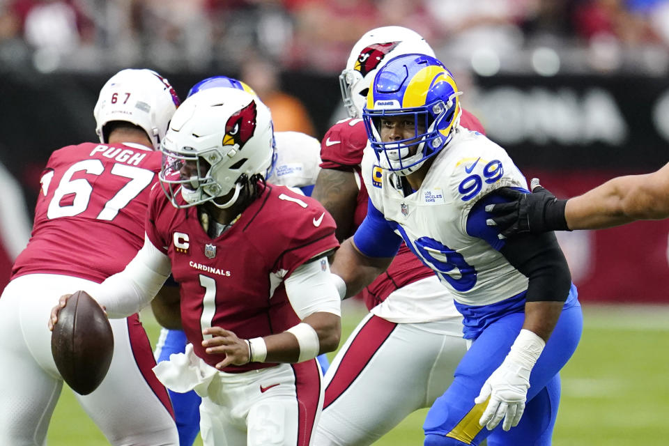 Arizona Cardinals quarterback Kyler Murray (1) tries to elude Los Angeles Rams defensive tackle Aaron Donald (99) during the first half of an NFL football game in Glendale, Ariz., Sunday, Sept. 25, 2022. (AP Photo/Ross D. Franklin)