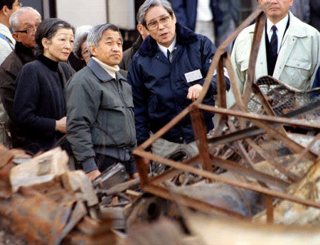 FILE PHOTO: Emperor Akihito, accompanied by Empress Michiko, gazes at the wreck left of buildings after the killer earthquake two weeks ago as a city official (R) explains during the monarch's tour to hard-hit disaster areas in Kobe January 31, 1995. REUTERS/Kimimasa Mayama/File Photo