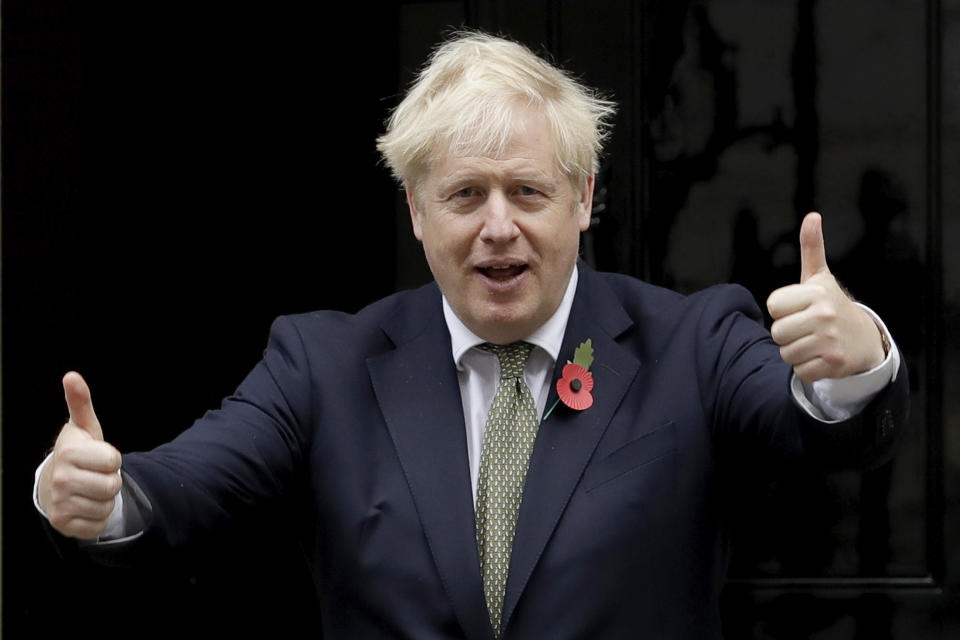 British Prime Minister Boris Johnson gives thumbs-ups as he poses for photographs with members of the British military to mark the launch of the annual Royal British Legion Poppy appeal outside 10 Downing Street, in London, Friday, Oct. 23, 2020. (AP Photo/Matt Dunham)