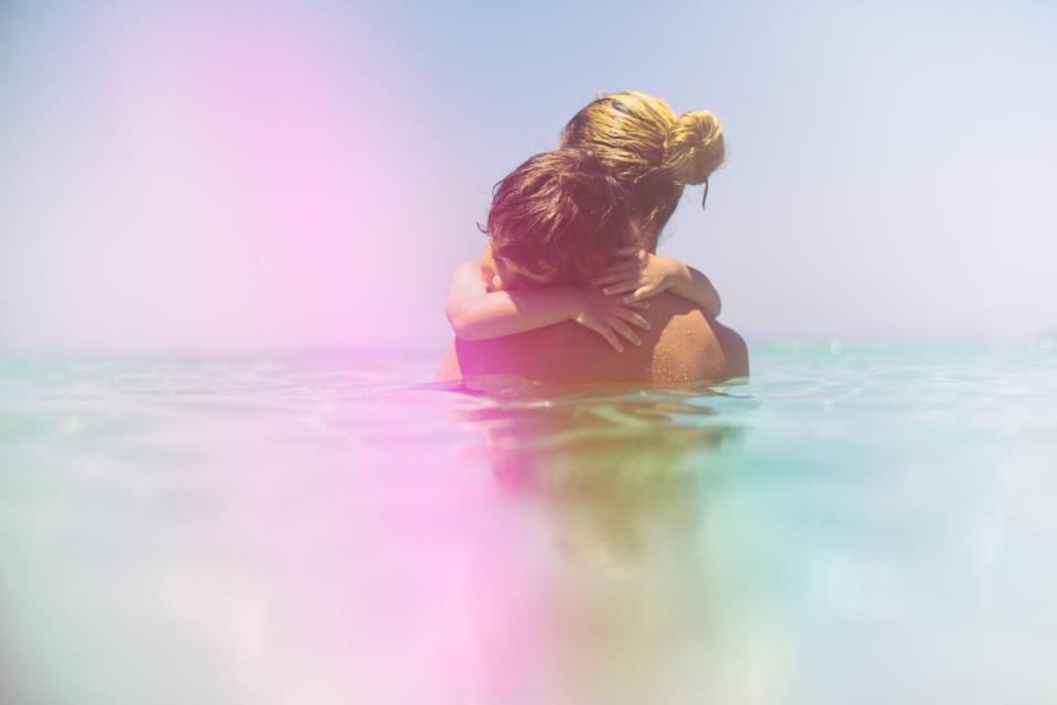 Woman holding child in sea