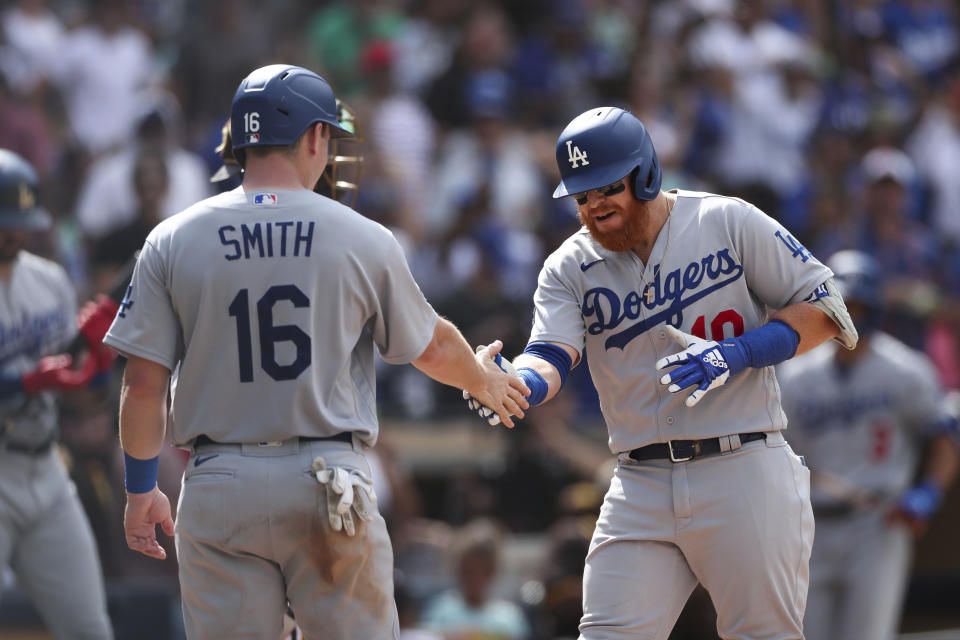 Los Angeles Dodgers' Justin Turner, right, is congratulated by Will Smith (16) after hitting a grand slam against the San Diego Padres in the seventh inning of a baseball game Sunday, Sept. 11, 2022, in San Diego. (AP Photo/Derrick Tuskan)