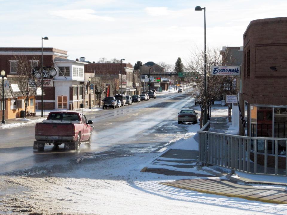 In this Jan. 2, 2014 photo, a pickup truck sporting Wyoming-themed mud flaps and a brush guard in front drives down Main Street in Lusk, Wyo. Electric cars are all but unheard of around here, but last month Tesla installed four of its Supercharger units in the courtyard of the Covered Wagon Motel in Lusk. A Supercharger can recharge a Tesla's depleted battery pack to a 90-percent level within 45-50 minutes, several times faster than any other charging option for the electric cars. Lusk is on the route of Tesla's first network of coast-to-coast Supercharger stations. The quick-charge stations promise to make cross-country travel by Tesla much quicker and easier. (AP Photo/Mead Gruver)