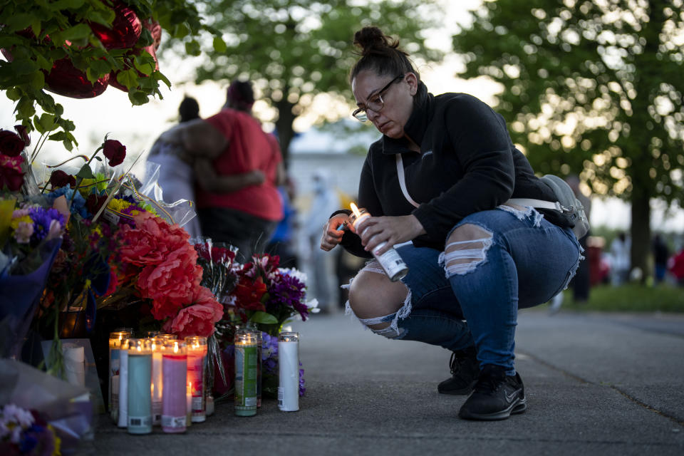 Ashley Padilla of Buffalo lights candles at a makeshift memorial as people gather at the scene of the Tops market massacre. 