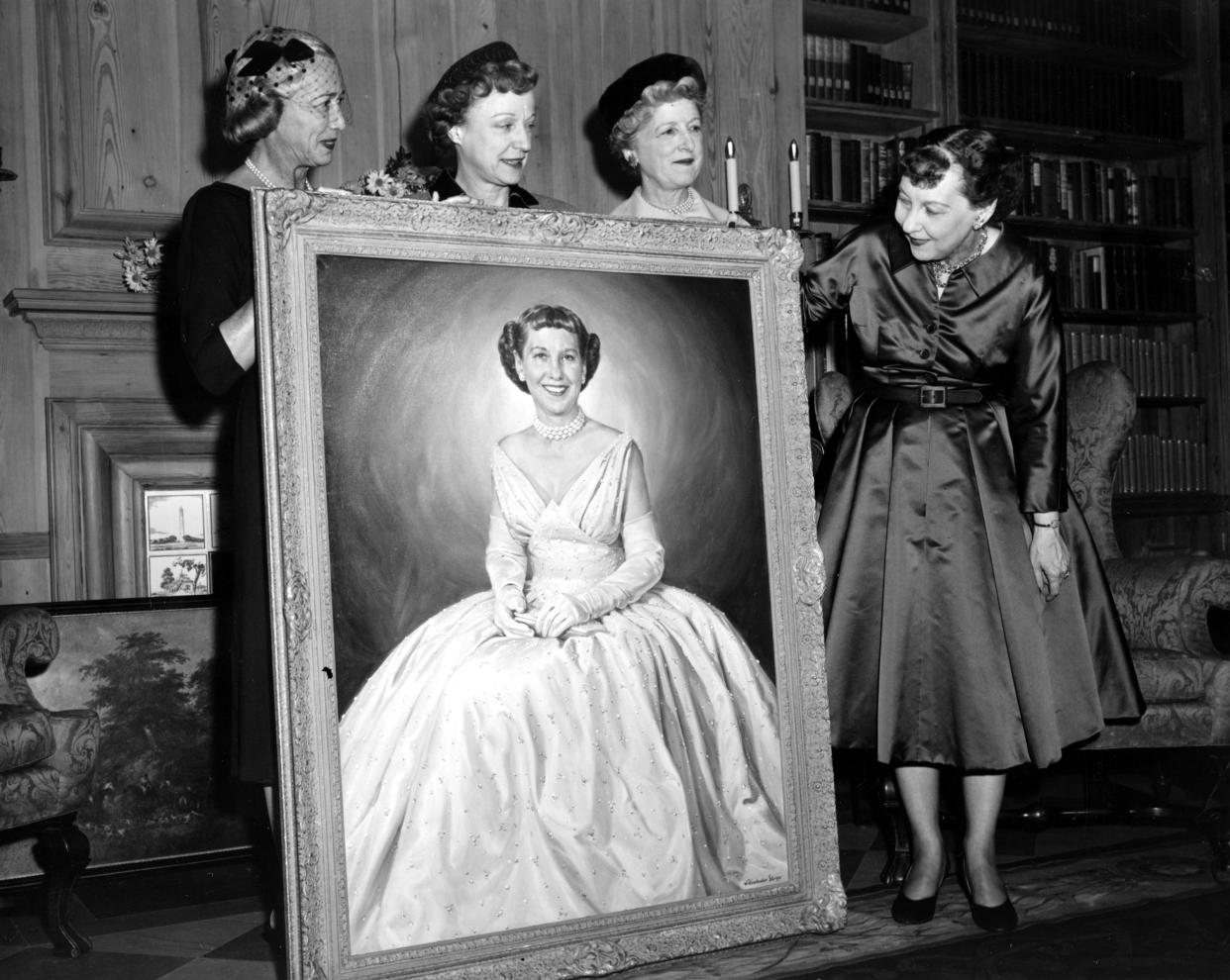 First Lady Mamie Eisenhower looks at an oil painting of herself, a gift for her sixtieth birthday, in the White House Library in Washington, D.C., Nov. 14, 1956. In the portrait, the first lady is wearing the pink gown worn at the inauguration ball. - Credit: ASSOCIATED PRESS