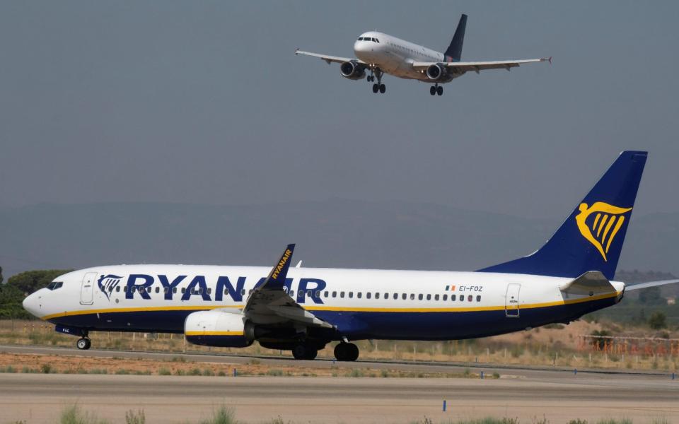 An aircraft approaches the airport next to a Ryanair plane ready to take off, ahead of a cabin crew strike to be held in four European countries on July 25 and 26 - REUTERS