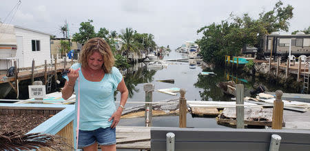 Terri Metter stands in front of what's left of destroyed trailers, that fill a canal near a trailer park in Marathon, Florida, U.S., June 10, 2018. Picture taken June 10, 2018. REUTERS/Zach Fagenson