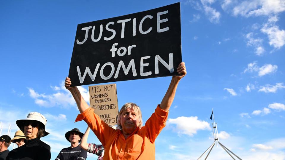 A woman at a rally to a call for action to end violence against women.