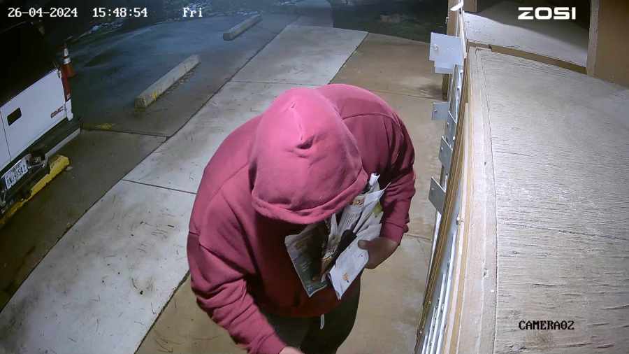 A suspect is seen gathering a bunch of mail.