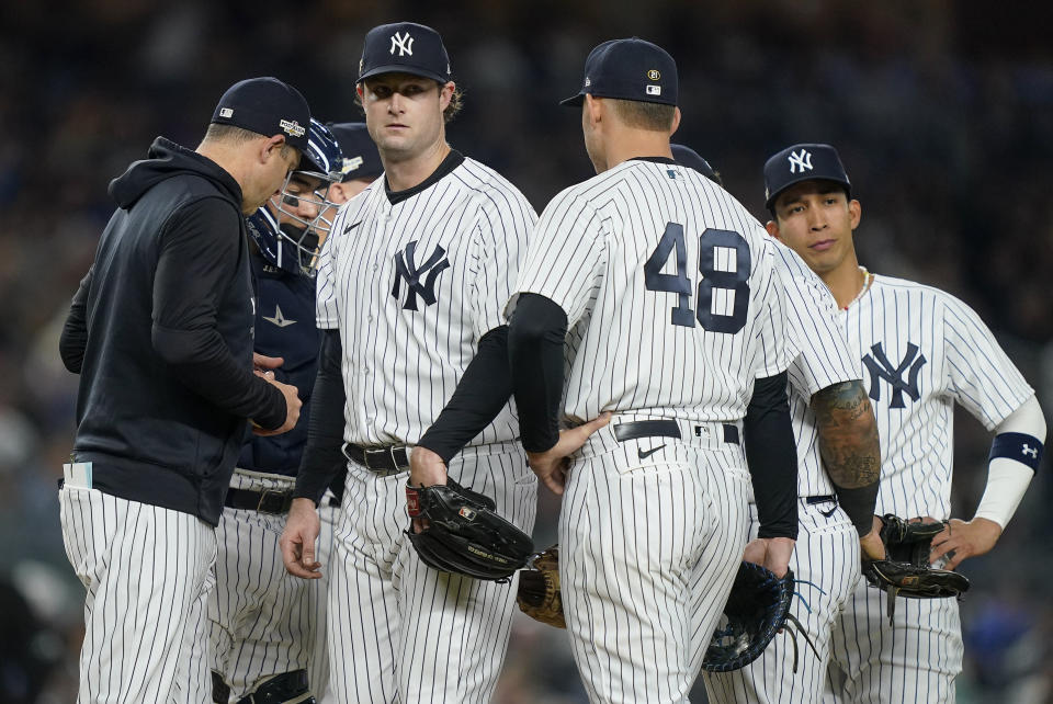 El abridor de los Yanquis de Nueva York Gerrit Cole (centro) al ser relevado en el sexto inning ante los Astros de Houston durante el tercer juego de la serie de campeonato de la Liga Americana, el sábado 22 de octubre de 2022. (AP Foto/John Minchillo)