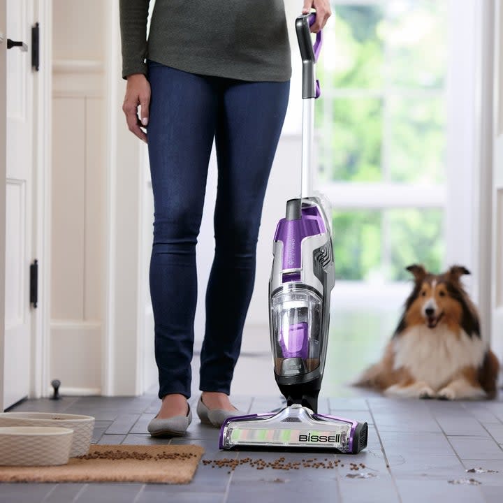model using the vacuum while a dog watches