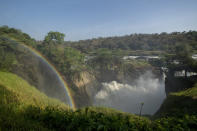 FILE - A rainbow forms in the mist at the top of the waterfalls in Murchison Falls National Park, northwest Uganda, on Feb. 22, 2020. Africa’s national parks, home to thousands of wildlife species are increasingly threatened by from below-average rainfall and new infrastructure projects, stressing habitats and the species that rely on them. Climate change and large-scale developments, including oil drilling and livestock grazing, are hampering conservation efforts in protected areas, several environmental experts say. (AP Photo, File)