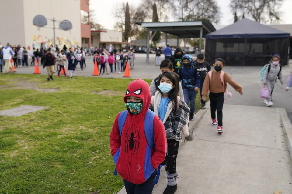 FILE - Students walk to class amid the COVID-19 pandemic at Washington Elementary School Jan. 12, 2022, in Lynwood, Calif. The governors of California, Oregon and Washington have announced that schoolchildren will no longer required to wear masks starting March 12, 2022. The governors of the three states announced the measure in a joint statement as part of new indoor mask policies that come as coronavirus case and hospitalization rates decline across the West Coast. (AP Photo/Marcio Jose Sanchez, File)