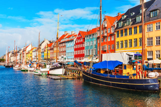 Scenic summer view of Nyhavn pier with color buildings, ships, yachts and other boats in the Old Town of Copenhagen, Denmark