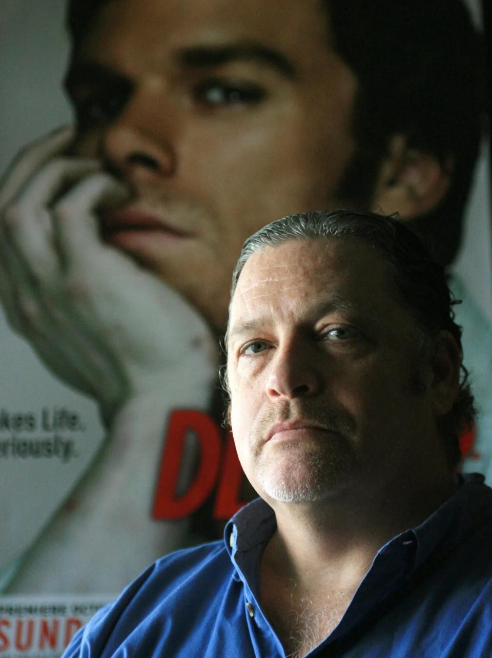 Author Jeff Lindsay in 2006 poses next to a poster from Showtime series “Dexter” at his home in Cape Coral. The eighth and final novel in the Dexter series, “Dexter Is Dead,” was published in July 2015. Lindsay said he has mixed feelings about leaving a popular character and a successful book series behind.