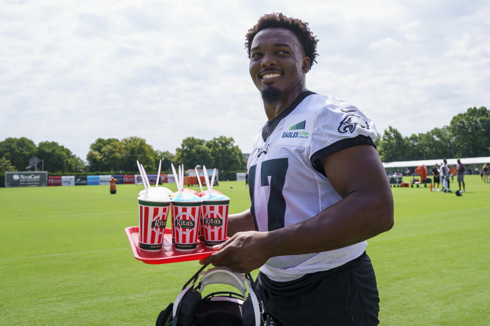 Philadelphia Eagles' Nakobe Dean walks back to the locker room with a trey of Italian water ice during practice at the NFL football team's training camp, Wednesday, July 27, 2022, in Philadelphia. (AP Photo/Chris Szagola)