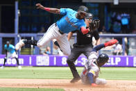 Miami Marlins shortstop Vidal Brujan, left, catches the throw, but is unable to tag Atlanta Braves' Ozzie Albies, as he steals second base during the third inning of a baseball game, Sunday, April 14, 2024, in Miami. (AP Photo/Wilfredo Lee)