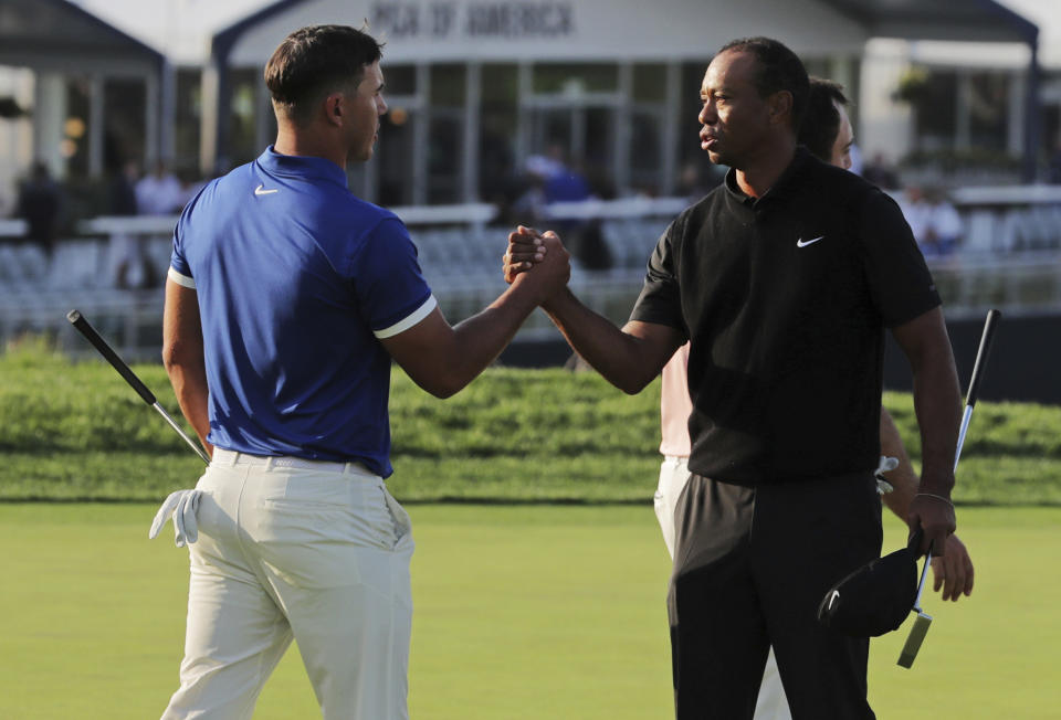 Brooks Koepka, left, shakes hands with Tiger Woods after finishing the second round of the PGA Championship golf tournament, Friday, May 17, 2019, at Bethpage Black in Farmingdale, N.Y. (AP Photo/Charles Krupa)