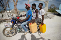 <p>Men ride a motorcycle in front of destroyed houses after Hurricane Matthew passes Jeremie, Haiti, October 7, 2016. (REUTERS/Carlos Garcia Rawlins)</p>