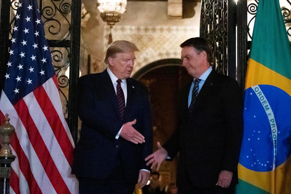 President Donald Trump shakes hands before a dinner with Brazilian President Jair Bolsonaro at Mar-a-Lago, Saturday, March 7, 2020, in Palm Beach, Fla.