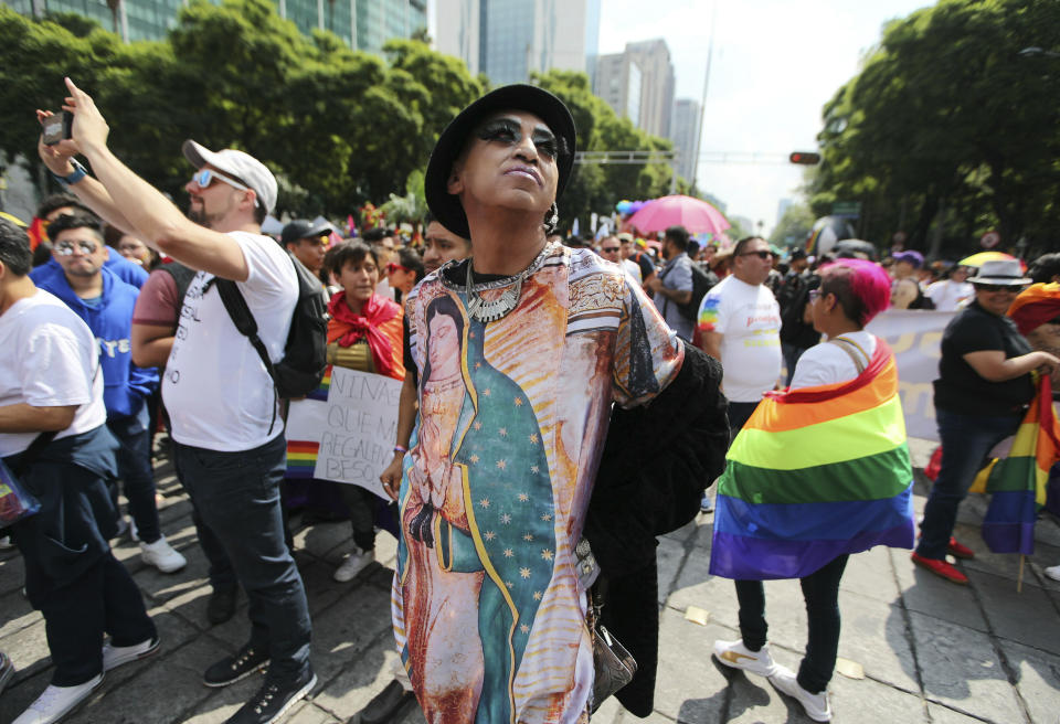 A reveler wearing a T-Shirt with the image of Guadalupe Virgin takes part in the gay pride parade in Mexico City, Mexico, Saturday, June 29, 2019. (AP Photo/Fernando Llano)