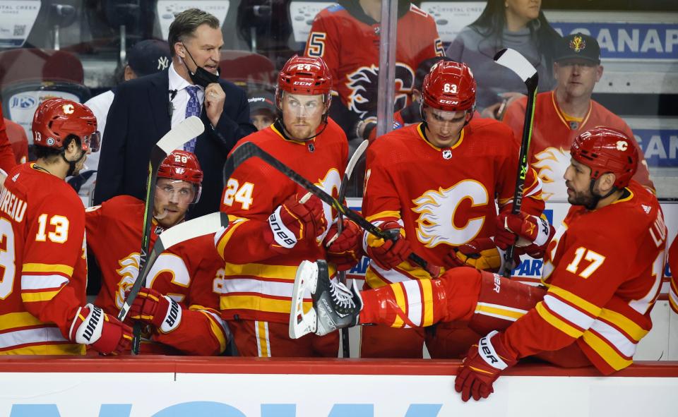 Calgary Flames associate coach Kirk Muller, back left, gives instruction during the first period of the team's NHL hockey game against the New York Islanders on Saturday, Feb. 12, 2022, in Calgary, Alberta. (Jeff McIntosh/The Canadian Press via AP)