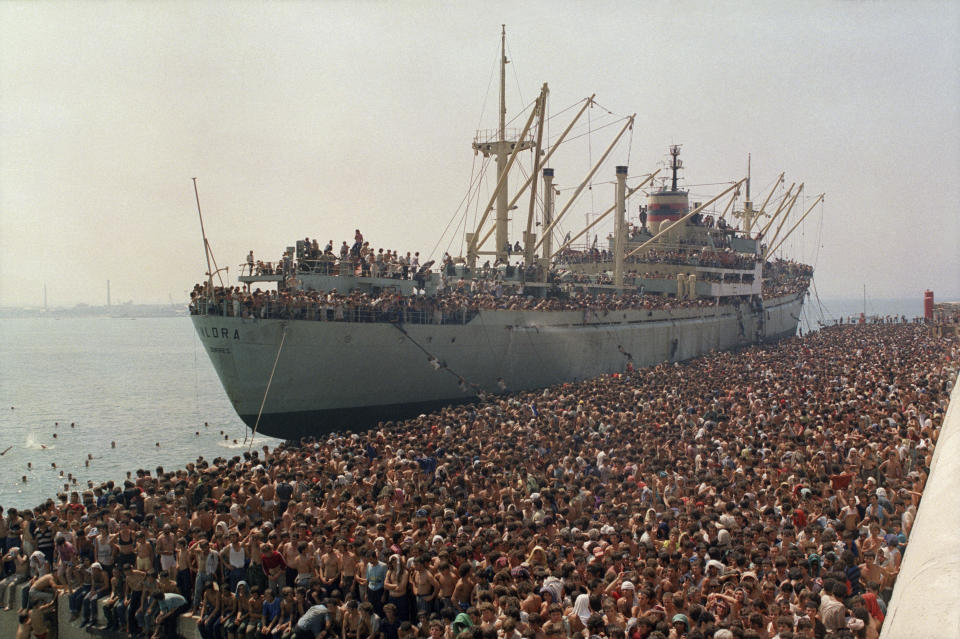 FILE - Thousands of Albanians, fleeing starvation in their impoverished homeland and seeking asylum in Italy, crowd the dock in Bari, Italy, Aug. 8, 1991, after disembarking from the freighter Vlora. Albania has agreed to host two migrant processing centers on its territory that will be run by Italy under a deal that worries human rights activists. The European Union, however, sees it as a possible future template. (AP Photo/Luca Turi, File)