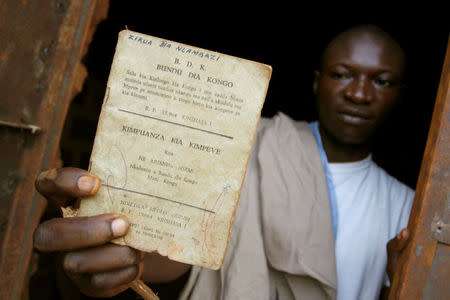 FILE PHOTO: A resident holds up a Bundu dia Kongo manifesto left behind after a police crackdown on the religious and political movement in Matadi, capital of Democratic Republic of Congo's volatile Bas Congo province, March 18, 2008.REUTERS/Joe Bavier/File Photo