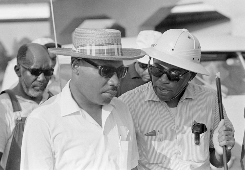 FILE - This June 25, 1966, file photo shows James Meredith, right, speaks with Dr. Martin Luther King after they met on U.S. 51 near Tougaloo, Miss. Dr. King had led a column of civil rights marchers from Tougaloo College to greet Meredith's marchers walking in from Canton. "Walk Against Fear: James Meredith," scheduled to air Thursday, Oct. 1, 2020, on the Smithsonian Channel, examines the life of a U.S. Air Force veteran-turn-human rights agitator whose admission into the University of Mississippi forced President John F. Kennedy to send federal troops into the state to quell a white supremacy uprising. (AP Photo, File)