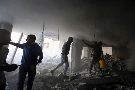 Palestinians react as they inspect a building hit by an Israeli air strike, in the southern Gaza Strip May 5, 2019. REUTERS/Ibraheem Abu Mustafa