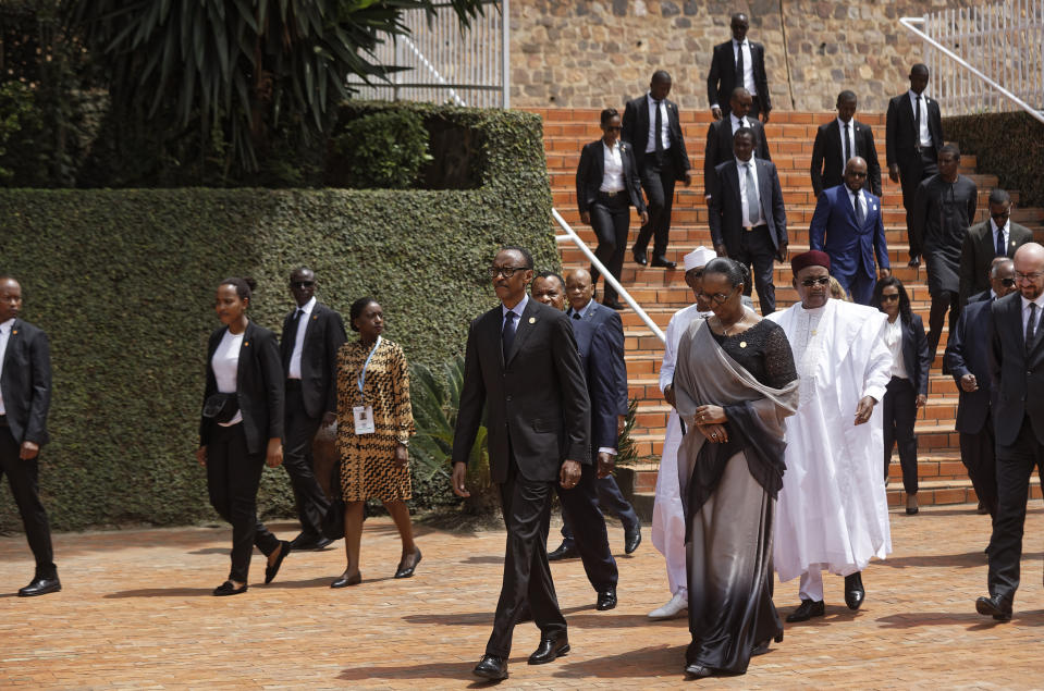 Rwanda's President Paul Kagame, center, and First Lady Jeannette Kagame, center-right, arrive at the Kigali Genocide Memorial in Kigali, Rwanda Sunday, April 7, 2019. Rwanda is commemorating the 25th anniversary of when the country descended into an orgy of violence in which some 800,000 Tutsis and moderate Hutus were massacred by the majority Hutu population over a 100-day period in what was the worst genocide in recent history. (AP Photo/Ben Curtis)