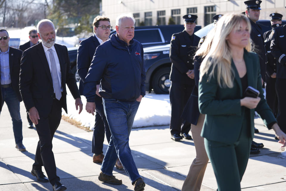 Minnesota Gov. Tim Walz, center, arrives at City Hall before a press conference after two police officers and a first responder were shot and killed Sunday, Feb. 18, 2024, in Burnsville, Minn. (AP Photo/Abbie Parr)