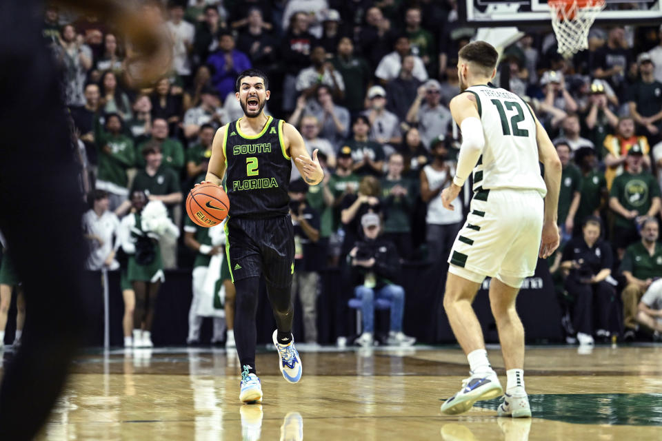 South Florida guard Jose Placer (2) brings the ball up court against Charlotte guard Jackson Threadgill (12) during the first half of an NCAA college basketball game on Saturday, March 2, 2024, in Charlotte, N.C. (AP Photo/Matt Kelley)