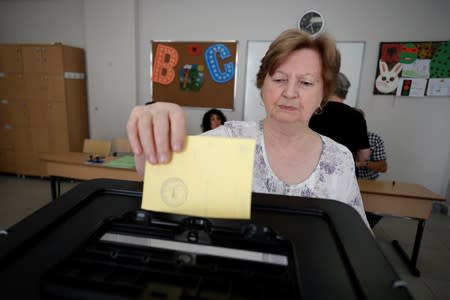 A woman casts a vote at a voting centre in Tirana