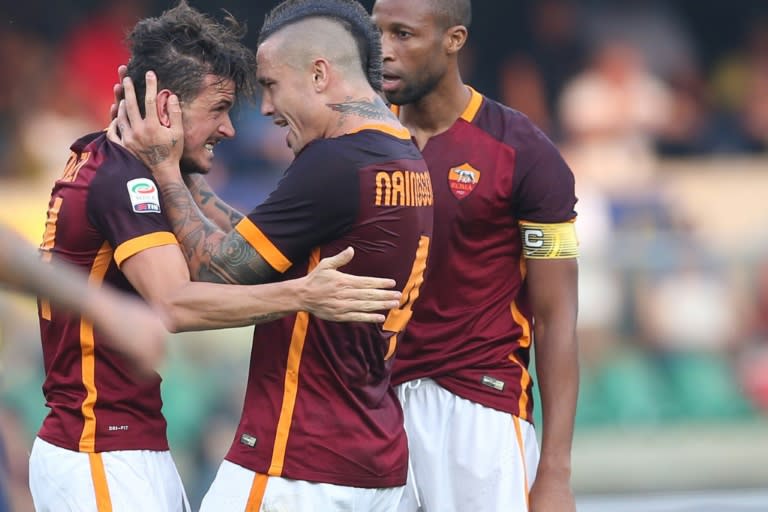 Roma's Alessandro Florenzi (L) celebrates with teammates Radja Nianggolan and Seydou Keita after scoring during the Serie A match against Verona at the Bentegodi stadium on August 22, 2015