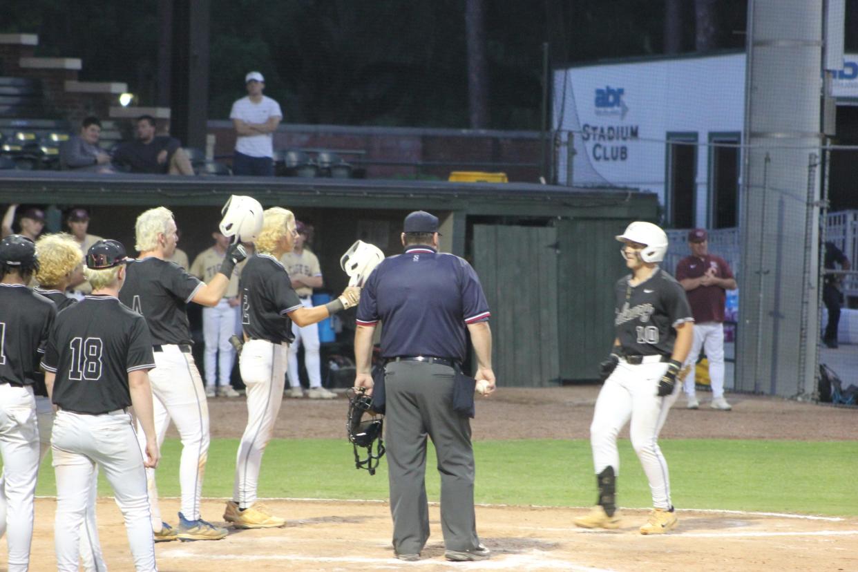 Calvary Day's Will Hampton is greeted by teammates after hitting a home run at Grayson Stadium in a playoff win over Dawson County on May 4, 2024.
