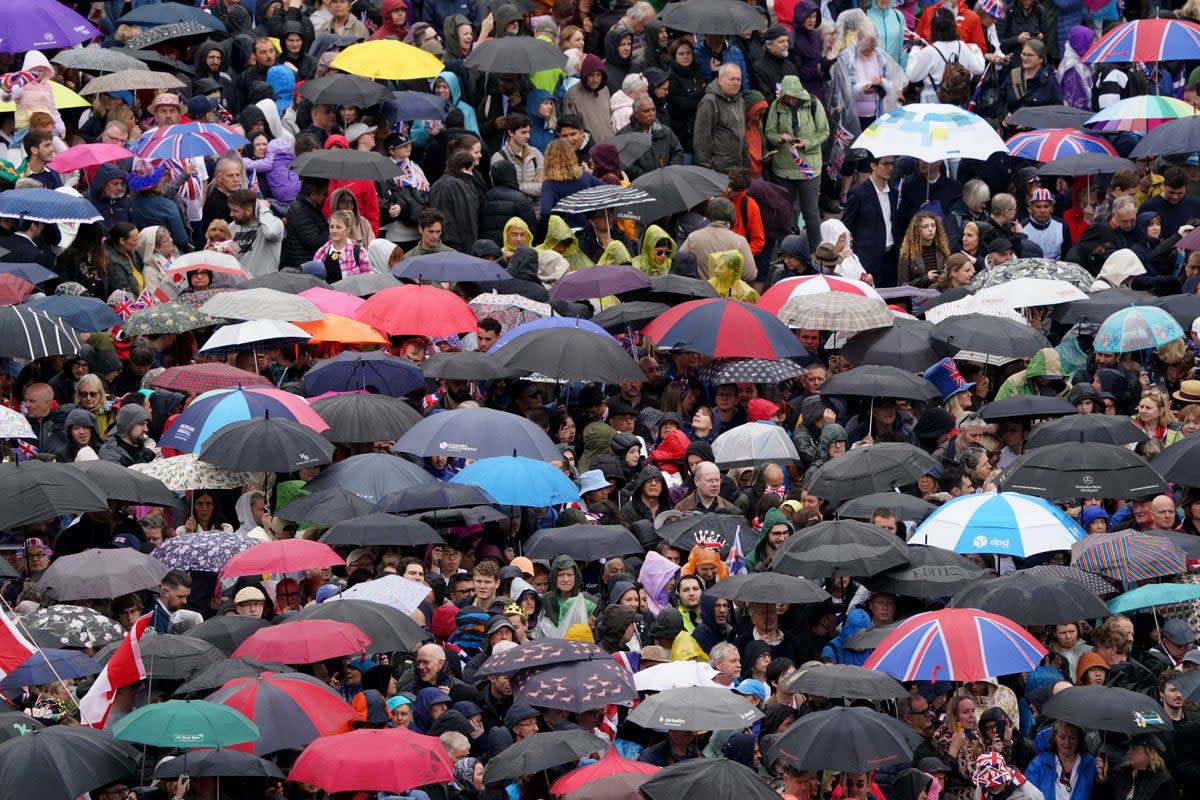 Crowds near Trafalgar Square take shelter from the rain ahead of the coronation ceremony of King Charles III and Queen Camilla (PA Wire)